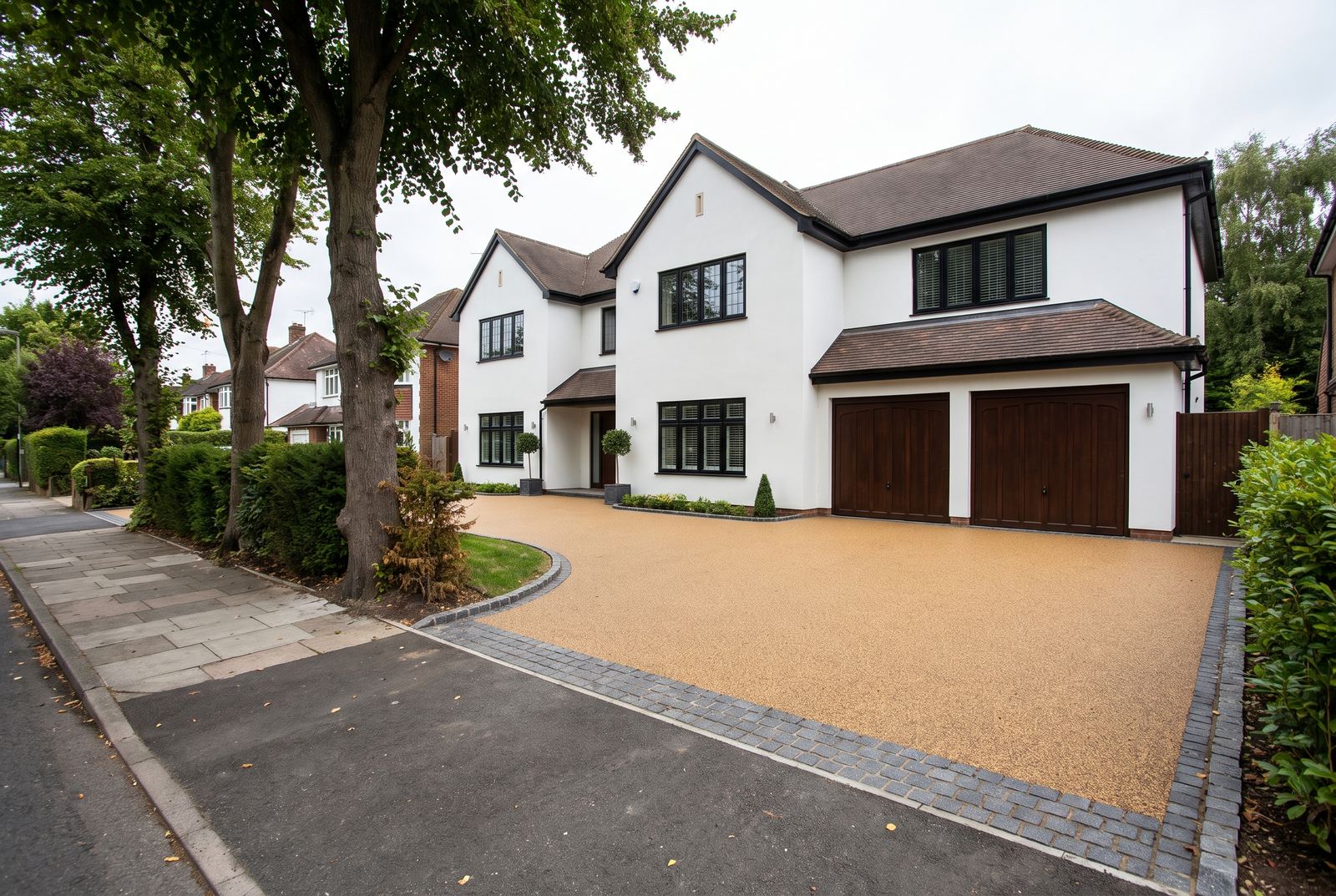 A broad resin bound parking area with a granite sett border